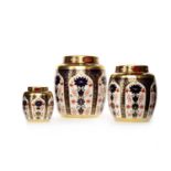 THREE GRADUATED ROYAL CROWN DERBY 'OLD IMARI' PATTERN GINGER JARS AND COVERS each with printed