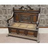 LATE VICTORIAN OAK HALL SETTLE the back with swan neck pediment,