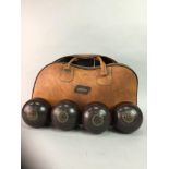 FOUR LAWN BOWLS CONTAINED IN CARRY BAG