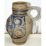 A RHENISH STONEWARE JUG, WITH SGRAFFITO COBALT DECORATION, THE FRONT WITH MOULDED G.R BOSS, 22CM