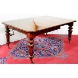 A LATE VICTORIAN OAK DINING TABLE, ON GLOBE KNOPPED OCTAGONAL LEGS WITH BRASS CASTORS, WITH A