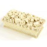 A FINELY CARVED IVORY BASKET SHAPED TRINKET BOX, THE DOMED LID PROFUSELY DECORATED WITH FLOWERS,