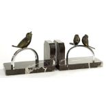 A PAIR OF ART DECO PATINATED BRONZE, CHROMIUM PLATED AND MARBLE BOOK ENDS, DESIGNED AS BIRDS ON AN