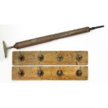 A SET OF EIGHT BRASS ELECTRIC SWITCHES ADAPTED AS COAT HOOKS MOUNTED ON STAINED WOOD BOARDS, 90CM