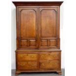 A GEORGE III OAK PRESS ADAPTED AS A WARDROBE, WITH PANELLED DOORS AND SIDES, THE LOWER PART FITTED