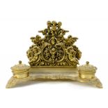 AN ORNATE VICTORIAN CAST BRASS INKWELL AND LETTER RACK, WITH MASK FEET, 30CM W