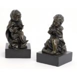 A PAIR OF CONTINENTAL BRONZE STATUETTES OF CHILDREN, C1880 naked but for a cloak and seated on a