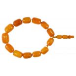 A NECKLACE OF SIXTEEN AMBER BEADS 62g