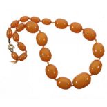 A NECKLACE OF TWENTY-ONE AMBER BEADS, 41g