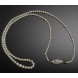 A NATURAL PEARL NECKLACE of 153 2.3-4.5mm approx natural (saltwater) pearls with diamond set shuttle