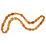 A NECKLACE OF THIRTY FOUR AMBER BEADS 58g