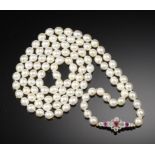 A NECKLACE OF CULTURED PEARLS WITH RUBY AND DIAMOND CLASP of approximately 6.5-7mm cultured