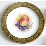 A ROYAL WORCESTER PLATE PAINTED BY A. SHUCK, SIGNED, WITH FRUIT, IN RICHLY GILT BLACK GROUND BORDER,