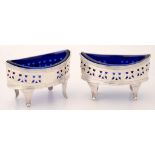 A PAIR OF GEORGE III PIERCED AND ENGRAVED SILVER SALT CELLARS OF NAVETTE SHAPE, ON FLUTED FEET, BLUE