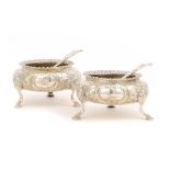 A PAIR OF VICTORIAN SILVER SALT CELLARS, CHASED WITH FLOWERS, CRESTED, 9CM DIAM, BY HENRY