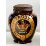 A 19TH C BROWN GLAZED EARTHENWARE TOBACCONIST'S SHOP JAR AND JAPANNED COVER, WITH CROWN TRANSFER AND