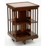 AN EDWARDIAN WALNUT ROTATING BOOKCASE OF SQUARE SHAPE WITH SLATTED SIDES, 53CM W