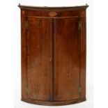 A GEORGE III MAHOGANY AND LINE INLAID BOW FRONTED CORNER CUPBOARD, THE FRIEZE WITH SHELL PATTERAE,