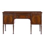A NEO CLASSICAL STYLE MAHOGANY SIDEBOARD, EARLY 20TH C of bow centred form with fluted frieze and