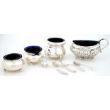 A SILVER MUSTARD POT, ONE AND A PAIR OF SILVER SALT CELLARS AND SEVERAL SILVER CONDIMENT SPOONS,