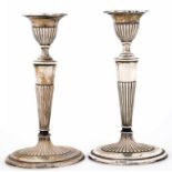 A PAIR OF GEORGE V NEO CLASSICAL STYLE SILVER CANDLESTICKS OF REEDED OVAL SHAPE, NOZZLES, 19CM H,