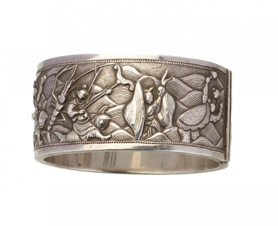 A CHINESE EXPORT SILVER REPOUSSE BANGLE, C1900 decorated to either side with groups of figures, 57 x