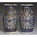 A PAIR OF 'CLOBBERED' CANTON BLUE AND WHITE VASES, 19TH C with applied gilt chilong and dog of Fo