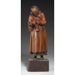 A BAVARIAN CARVED AND STAINED LIMEWOOD FIGURE OF AN ELDERLY LADY, 20TH C in wire spectacles, 36cm