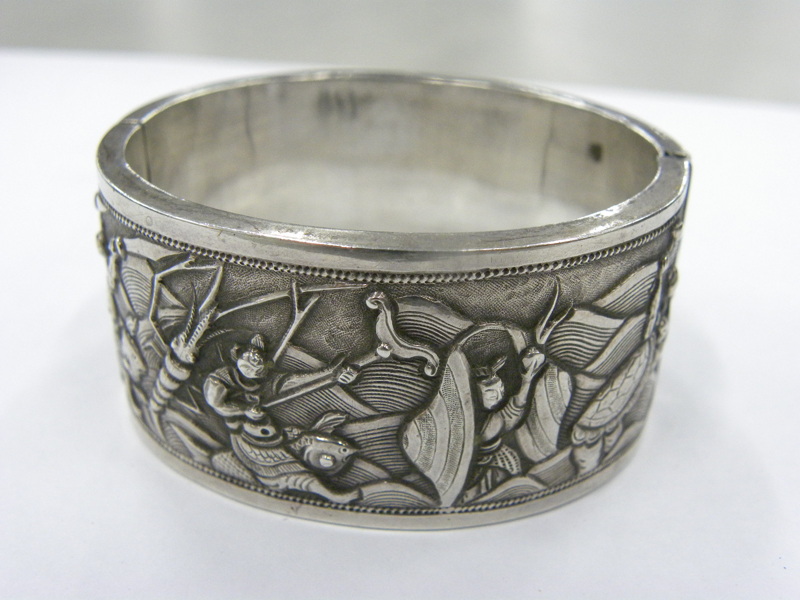 A CHINESE EXPORT SILVER REPOUSSE BANGLE, C1900 decorated to either side with groups of figures, 57 x - Image 2 of 5