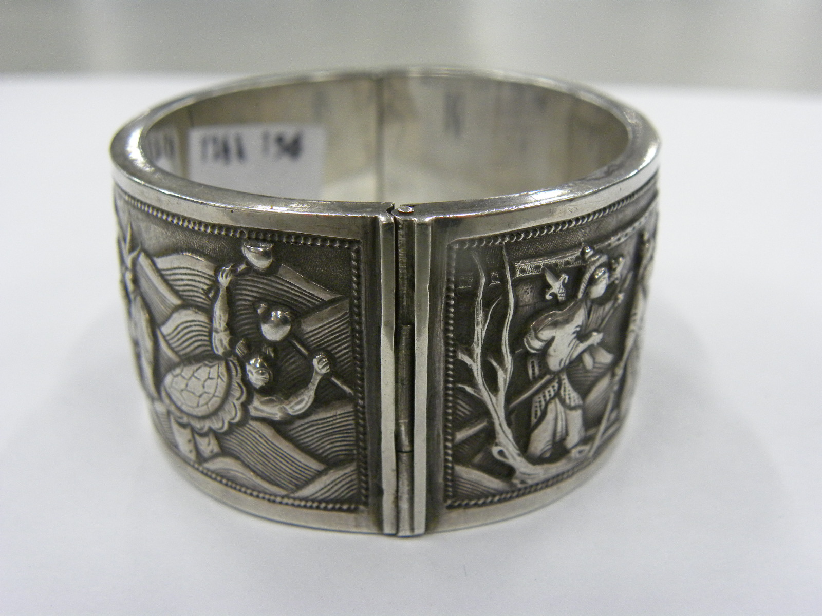 A CHINESE EXPORT SILVER REPOUSSE BANGLE, C1900 decorated to either side with groups of figures, 57 x - Image 5 of 5