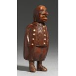 TREEN. A CARVED COQUILLA NUT SNUFF BOX IN THE FORM OF A GROTESQUE MAN, GERMAN OR DUTCH, EARLY 19TH C