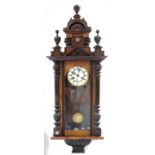 A WALNUT 'VIENNA' WALL CLOCK, WITH ARCHITECTURAL PEDIMENT, ENAMEL DIAL AND GRID IRON PENDULUM, 104CM