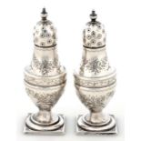 A PAIR OF VICTORIAN SILVER VASE SHAPED PEPPER CASTERS, ENGRAVED WITH SWAGS ON SQUARE FOOT, 10.5CM H,