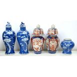 A PAIR OF CHINESE BLUE AND WHITE INVERTED BALUSTER VASES AND COVERS, PAINTED WITH PRUNUS ON A