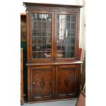 A STAINED AND CARVED OAK GLAZED BOOKCASE, THE LOWER PART WITH PANELLED DOORS, EARLY 20TH C, 207CM H;
