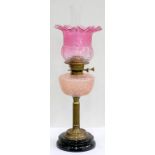 AN EDWARDIAN BRASS OIL LAMP, WITH REEDED PILLAR AND SEMI-OPALESCENT PINK MOULDED GLASS FOUNT,