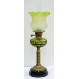 AN EDWARDIAN BRASS SPIRALLY FLUTED OIL LAMP WITH IRIDESCENT TRAILED GREEN GLASS FOUNT, BRASS