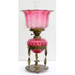 AN EDWARDIAN BRASS OIL LAMP WITH DETACHABLE SPIRALLY LOBED CRANBERRY GLASS FOUNT, WITH BRASS