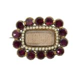 A VICTORIAN GARNET AND SPLIT PEARL MOURNING BROOCH, C 1840 in gold, the centre inset with hair, 30 x