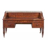 A WILLIAM IV POLLARD OAK DESK, C1830 the leather inlet top with brass gallery to the superstructure,