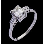 A DIAMOND SOLITAIRE RING the emerald cut diamond weighing approx 0.7ct with two baguette cut