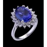 A TANZANITE AND DIAMOND CLUSTER RING the oval tanzanite 14 x 10mm, in platinum, millennial mark, 9.