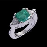 AN EMERALD AND DIAMOND THREE STONE RING the princess cut emerald 8 x 8mm with two trilliant cut