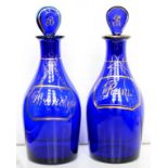 A PAIR OF 'BRISTOL' BLUE GLASS DECANTERS AND STOPPERS WITH GILT RUM OR BRANDY LABEL, 21.5CM H, CIRCA