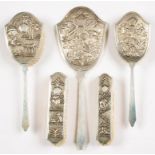 A SOUTH EAST ASIAN FOUR PIECE SILVER REPOUSSÉ BRUSH SET, MARKED STERLING SILVER, CIRCA MID 20TH C
