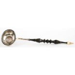 A SILVER PUNCH LADLE, THE BOWL INSET WITH A QUEEN ANNE SHILLING, ON FINELY TURNED WOOD AND BONE