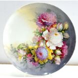 AN OUTSIDE DECORATED EARTHENWARE PLATE, PAINTED WITH BRIGHTLY COLOURED FLOWERS ON A SHADED GROUND,