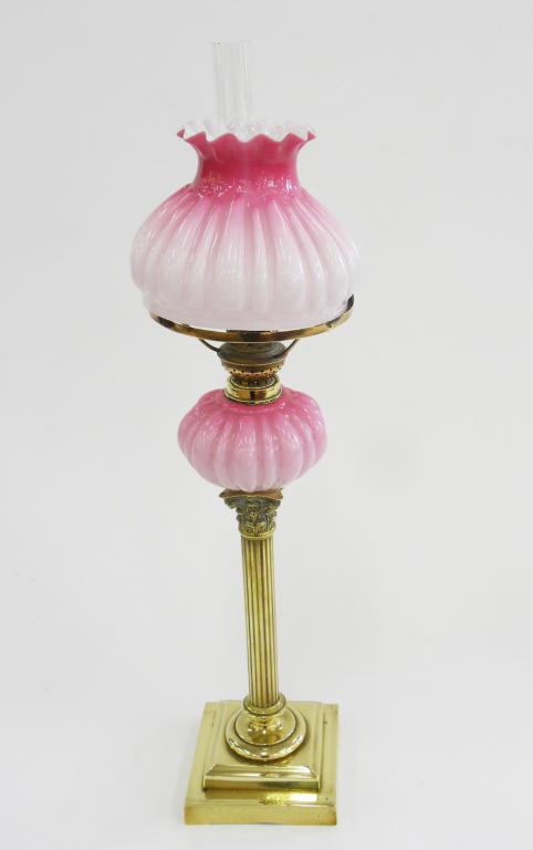 A VICTORIAN BRASS CORINTHIAN COLUMN OIL LAMP WITH PINK SHADED GLASS FOUNT, BRASS BURNER AND MATCHING