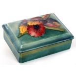 A MOORCROFT ORCHID BOX AND COVER, DESIGNED BY WALTER MOORCROFT, CIRCA 1950, 12CM L, IMPRESSED