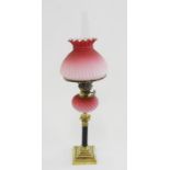 A VICTORIAN BRASS COLUMNAR OIL LAMP WITH SPIRALLY REEDED PINK SATIN GLASS FOUNT, BRASS BURNER AND